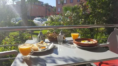a table with a plate of food and two glasses of orange juice at Duplex el Madina in Marrakech