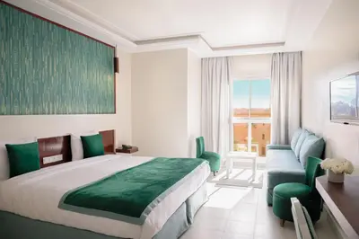 a hotel room with a bed and a desk and chair at Hotel Safia in Marrakech