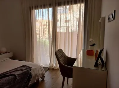 a bedroom with a desk and a bed and a window at Appartement cosy au cœur de Marrakech avec piscine in Marrakech
