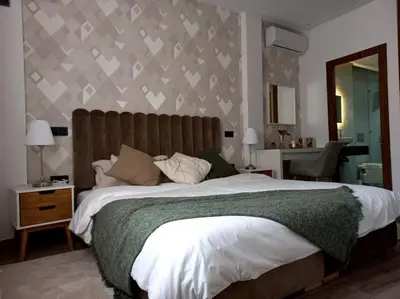 a bedroom with a large bed and a mirror at Appartement cosy au cœur de Marrakech avec piscine in Marrakech