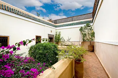 a courtyard of a building with purple flowers at Riad 92 - Architect's Riad in the Exclusive Dar El Bacha in Marrakech