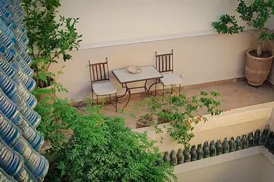 a table and chairs in a room with plants at Riad 92 - Architect's Riad in the Exclusive Dar El Bacha in Marrakech