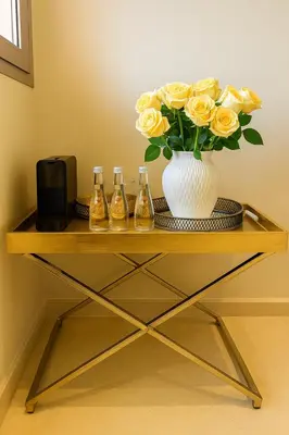 a table with a vase with yellow roses in it at Appartement de luxe prestigia Golf Resort in Marrakech
