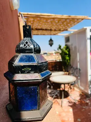 a blue glass lantern sitting on the side of a building at Riad MS holidays terrasse privatisé Marrakech in Marrakech