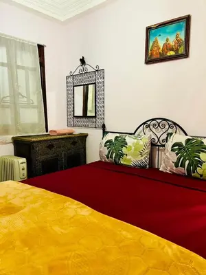 a bedroom with a yellow bed and a mirror at Riad MS holidays terrasse privatisé Marrakech in Marrakech