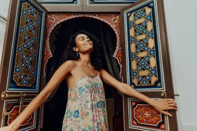 a woman in a dress standing in front of a door at Kenzara Suites & Pool, Your private escape in Marrakech