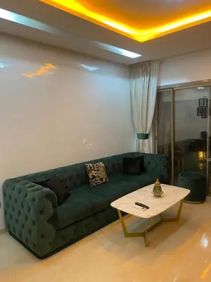 a living room with a green couch and a table at Oasi Marrakech in Marrakech