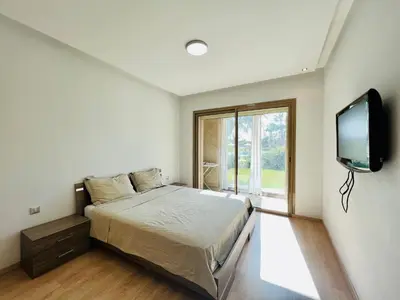 a bedroom with a bed and a flat screen tv at Corail Apart Golfique -Prestigia in Marrakech