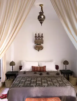 a bedroom with a bed and a chandelier at Riad Al Wifak in Marrakech