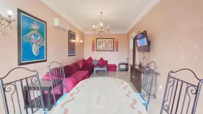 a living room with a pink couch and a table at Résidence Anas Majorelle -Centre Ville in Marrakech