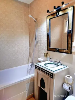 a bathroom with a sink and a mirror and a tub at Riad Darnooz Marrakech in Marrakech