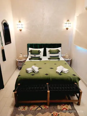 a bedroom with a bed with two towels on it at Riad Darnooz Marrakech in Marrakech