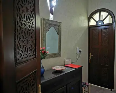 a bathroom with a sink and a mirror and a door at Maison de standing - Médina de Marrakech in Marrakech