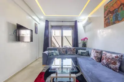 a living room with a blue couch and a table at NEW! Plein Gueliz, terrasse, wifi in Marrakech