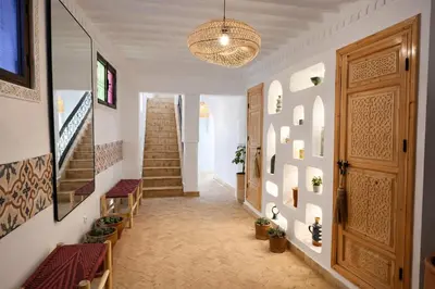 a hallway of a home with stairs and a chandelier at RIAD JOUJ- Oasis privée avec bassin et SPA - kasbah in Marrakech
