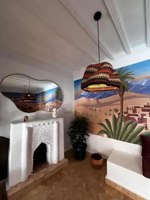 a living room with a fireplace and a painting at RIAD JOUJ- Oasis privée avec bassin et SPA - kasbah in Marrakech