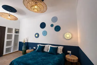 a bedroom with a blue bed and blue plates on the wall at RIAD JOUJ- Oasis privée avec bassin et SPA - kasbah in Marrakech