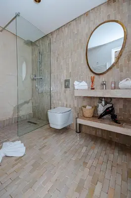 a bathroom with a shower and a toilet and a mirror at RIAD DAR BAYANE in Marrakech