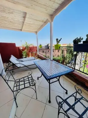 a patio with a table and chairs on a balcony at résidence qarya syahia private roof terrasse in Marrakech