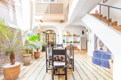 a living room with plants and a staircase at Riad Kasbabouch - Breakfast - 10mn to Jamaa Al Fna in Marrakech
