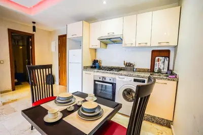 a kitchen with a table and a stove and a dishwasher at Apartment pool marrakech in Marrakech