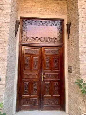 a large wooden door with a sign on it at Cosy appartement au cœur de Gueliz in Marrakech