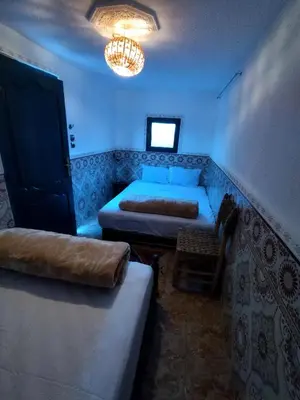 a room with two beds and a chandelier at Kesh apartment in Marrakech