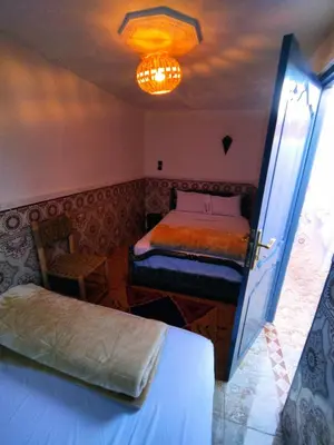 a bedroom with two beds and a chandelier at Kesh apartment in Marrakech