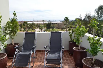 two chairs sitting on a balcony with trees at JHDARINNA in Marrakech