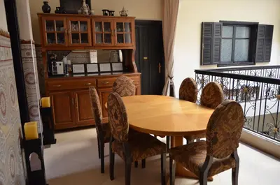 a dining room with a wooden table and chairs at JHDARINNA in Marrakech