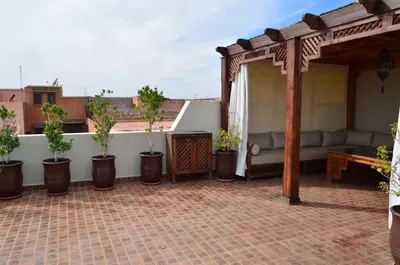 a patio with a couch and potted plants at JHDARINNA in Marrakech