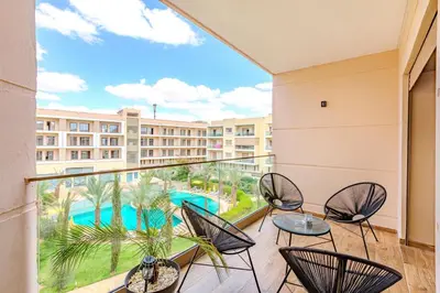 a balcony with chairs and a view of a resort at Royal Deluxe Diamond - Marrakech, Luxe Pool View in Marrakech