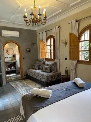 a bedroom with a large bed and a couch at Riad Al Nubala in Marrakech