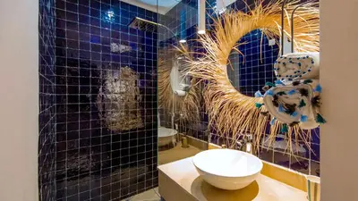 a bathroom with a toilet and a blue tiled wall at RIAD 48 & SPA in Marrakech