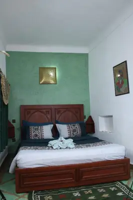 a bedroom with a large wooden bed in a room at Riad dar Karam in Marrakech