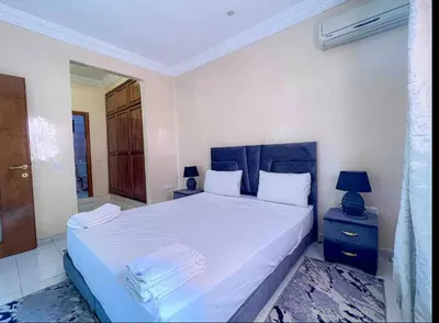a bedroom with a large white bed with a blue headboard at Marrakech Mirage Home in Marrakech