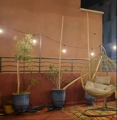 a room with three potted plants and a swing at Marrakech Mirage Home in Marrakech