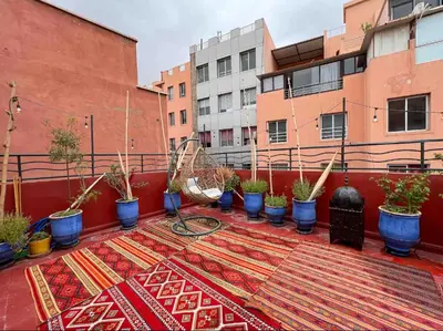 a balcony with a rug and potted plants on it at Marrakech Mirage Home in Marrakech