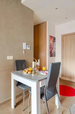 a dining room with a white table and chairs at Coquet studio pour vacance in Marrakech