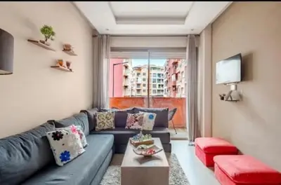 a living room with a blue couch and a window at Coquet studio pour vacance in Marrakech