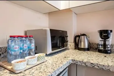 a kitchen counter with bottles of water and a microwave at Coquet studio pour vacance in Marrakech