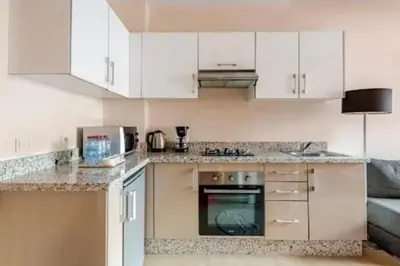 a kitchen with white cabinets and a stove top oven at Coquet studio pour vacance in Marrakech