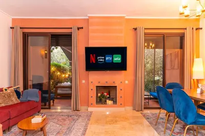 a living room with a couch and a tv on a wall at Pavillon Affaoui Golf & Waky in Marrakech