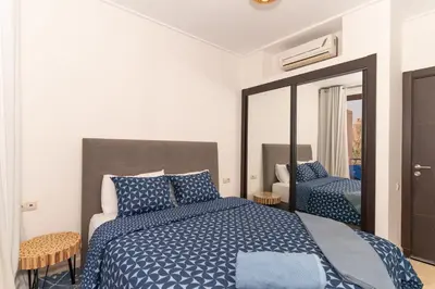 a bedroom with a blue bed and a mirror at Pavillon Affaoui Golf & Waky in Marrakech
