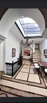 a room with a skylight and stairs with a table and chairs at Riad privatisé jusqu a 5 personnes a 5 minutes place jemma El fna loué avec ménage et petit déjeuner compris in Marrakech