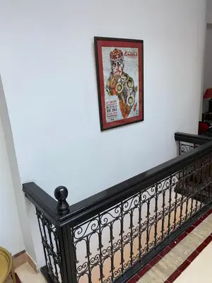 a picture hanging on a white wall next to a staircase at Riad privatisé jusqu a 5 personnes a 5 minutes place jemma El fna loué avec ménage et petit déjeuner compris in Marrakech