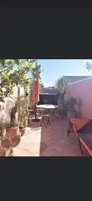 a patio with a table and chairs and plants at Riad privatisé jusqu a 5 personnes a 5 minutes place jemma El fna loué avec ménage et petit déjeuner compris in Marrakech