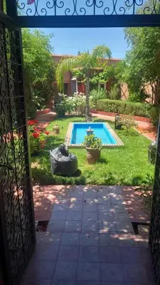 an open door to a yard with a swimming pool at Maison ALPHEA SPA HAMMAM in Marrakech