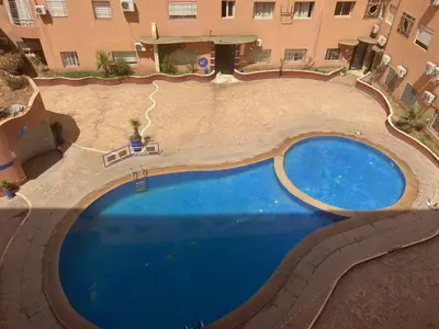 an overhead view of a swimming pool in front of a building at Appartment Zaina in Marrakech