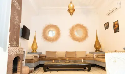 a living room with a couch and a fireplace at Ryad de charme authentique piscine calme in Marrakech